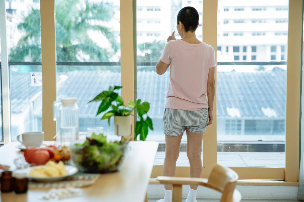 Patient schaut aus dem Fenster mit einem Tisch mit Essen im Vordergrund.