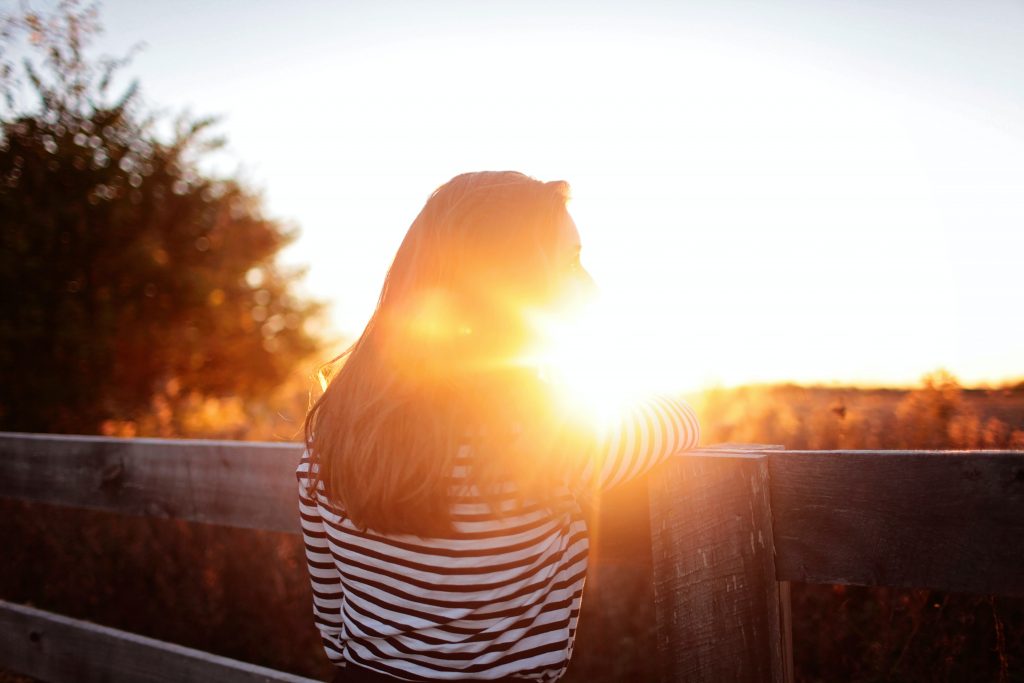 Frau, die bei Sonnenuntergang anstarrt.